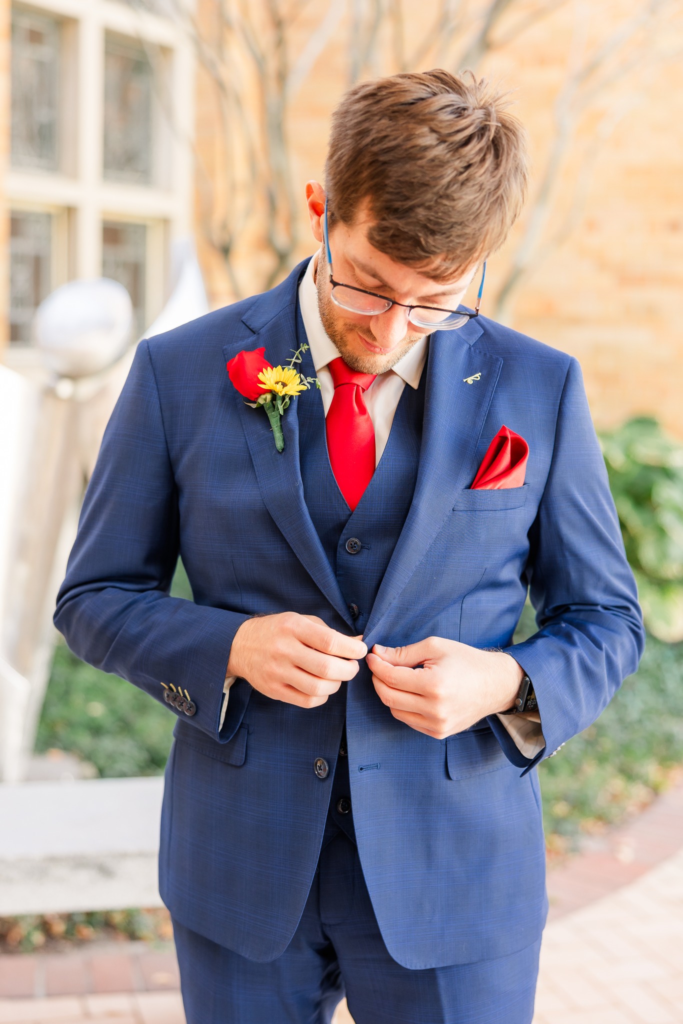 groom buttoning suit jacket
